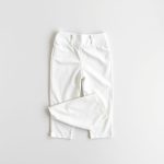 White cropped yoga pants with invisible scrunch folded neatly on a neutral surface, top-down view.
