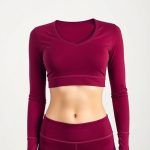 A burgundy long sleeve yoga top, cropped gym tshirt for women, on white background, hyperrealistic studio photo.