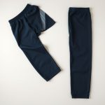 Navy blue wide leg yoga pants for women, neatly folded black jogger pants womens on a neutral surface, top-down view.