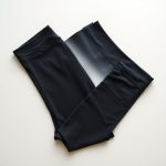 Flat lay of charcoal black pocket leggings with activewear pockets, neatly folded on a neutral surface.