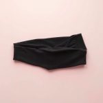 Flat lay of pastel pink black wide leg yoga pants scrunch legging folded neatly on a neutral surface.