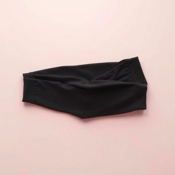 Flat lay of pastel pink black wide leg yoga pants scrunch legging folded neatly on a neutral surface.