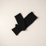 Black yoga pants flare from Luna, neatly folded in a flat lay on a clean surface.