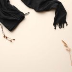 Flat lay of the boho clothing brand chai loose leaf top in black, neatly folded on a neutral surface.
