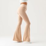 Beige flare active pants sculpting dreams, hyperrealistic studio photo on white background.