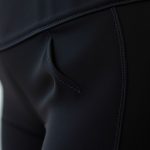 Close-up of black high waisted yoga pants fabric showing texture, stitching, and quality with pockets.