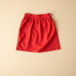 Flat lay of a Red mini skirt cream | sar to aus, neatly folded on a clean, neutral surface.