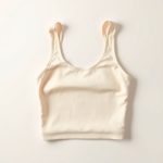 Flat lay of a Beige Lenzing Ecovero white yoga top, neatly folded on a clean surface.