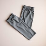 Flat lay of womens golf pants in Heather Grey, neatly folded on a neutral surface, golf clothes women Australia.