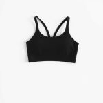 Black yoga crop top and pink gym shorts on a white background, hyperrealistic studio photo.