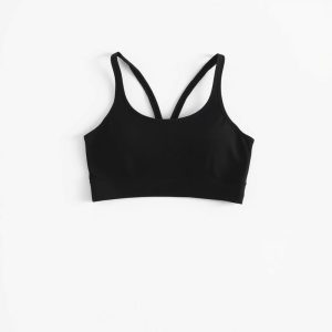 Black yoga crop top and pink gym shorts on a white background, hyperrealistic studio photo.
