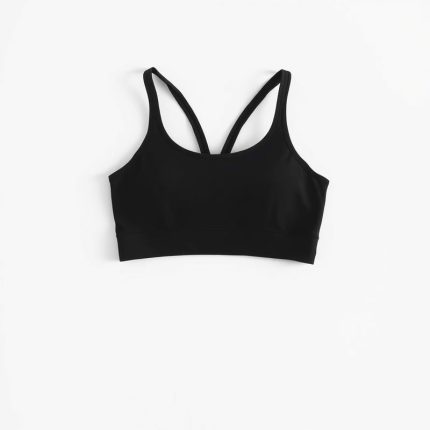 Black yoga crop top and pink gym shorts on a white background, hyperrealistic studio photo.
