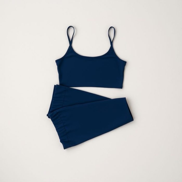 Navy Blue yoga crop top and fitted flare pants set, flat lay on a neutral surface.