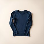 Navy Blue organic cotton yoga long sleeve top folded flat on a neutral surface.