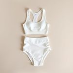 White organic knit yoga set from Australia, neatly folded on a neutral surface.