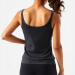 Back view of a charcoal organic activewear yoga singlet on a model, studio shot.