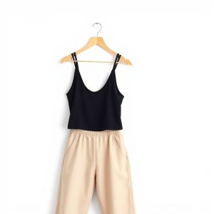 A beige yoga top paired with black flared yoga pants on a white background.