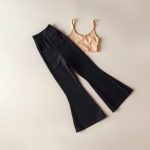 Beige yoga top and black flared yoga pants, neatly folded in a minimalist flat lay.