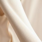 Close-up detail of the soft, sustainable Econyl fabric on a long sleeve yoga top, showing quality stitching.