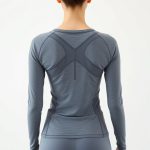 Back view of a Heather Grey yoga top long sleeve in Econyl fabric on a model.